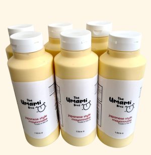theumamibros.com A case of Japanese Style Mayonnaise (1 Litre) includes six cream-coloured bottles with white labels featuring black and red text, closely arranged for an authentic appearance.